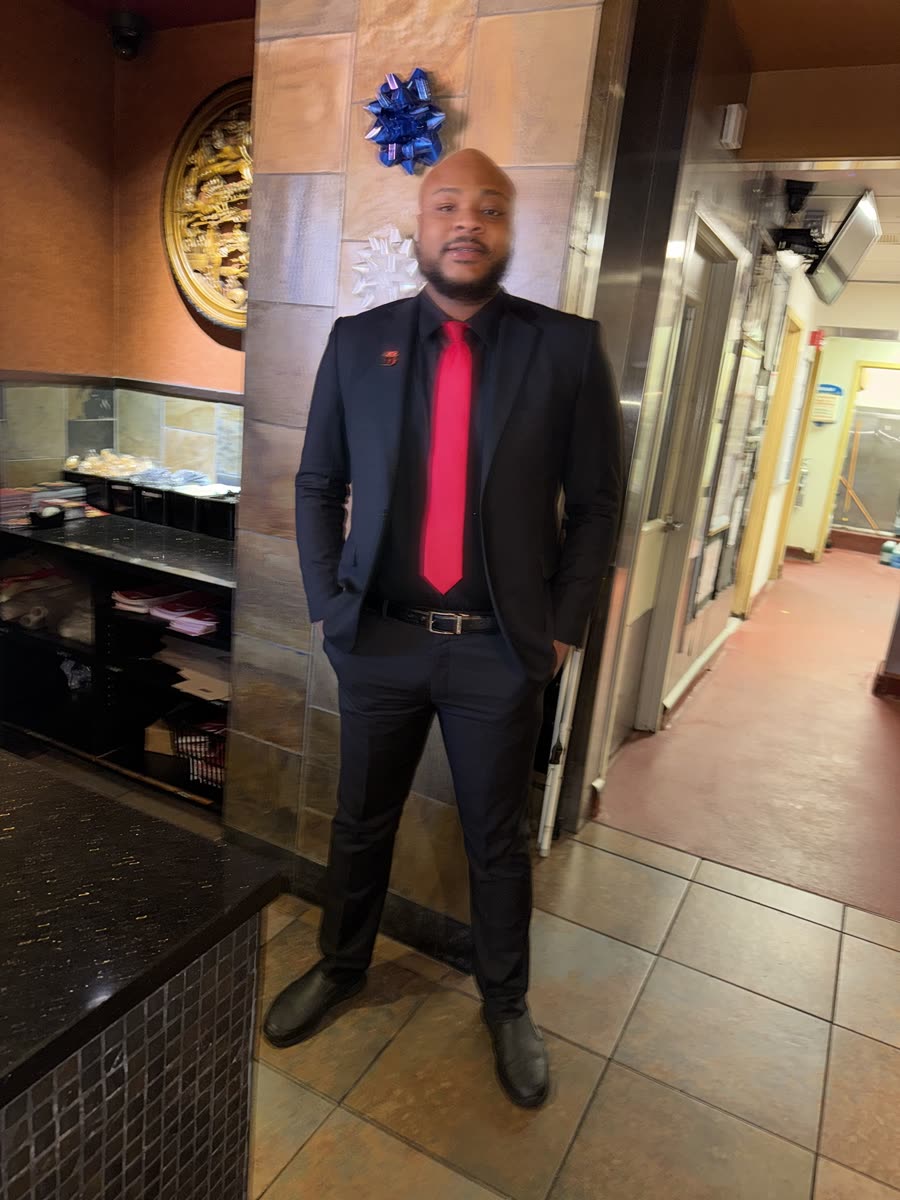 Scottie Stowe in a black suit and red tie