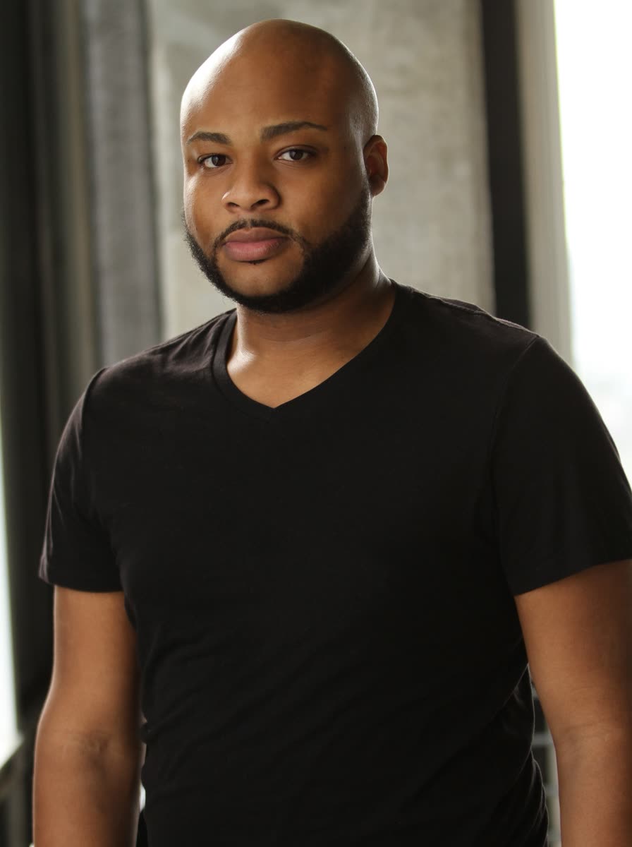 Three-quarter headshot of Scottie Stowe in a black t-shirt by a window
