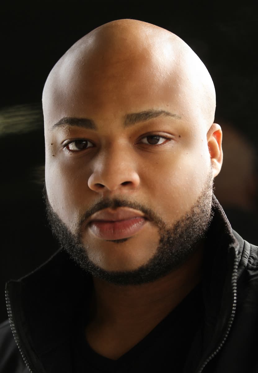 Dramatic, low-key headshot of Scottie Stowe in a black zip jacket